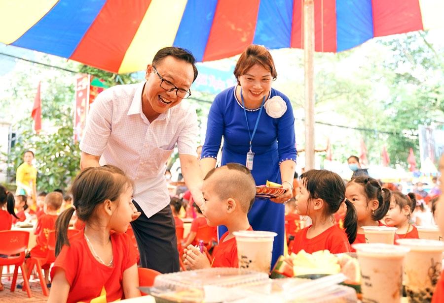 Đồng chí Thào Hồng Sơn phát quà cho các cháu học sinh Trường Mầm non Quang Trung.