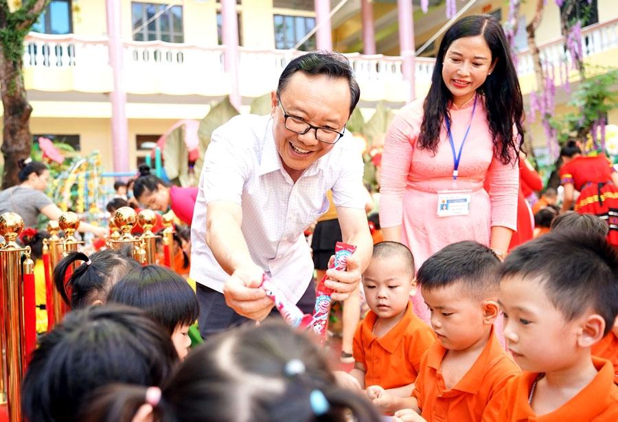 Đồng chí Thào Hồng Sơn phát quà cho các cháu học sinh Trường Mầm non Hoa Hồng.