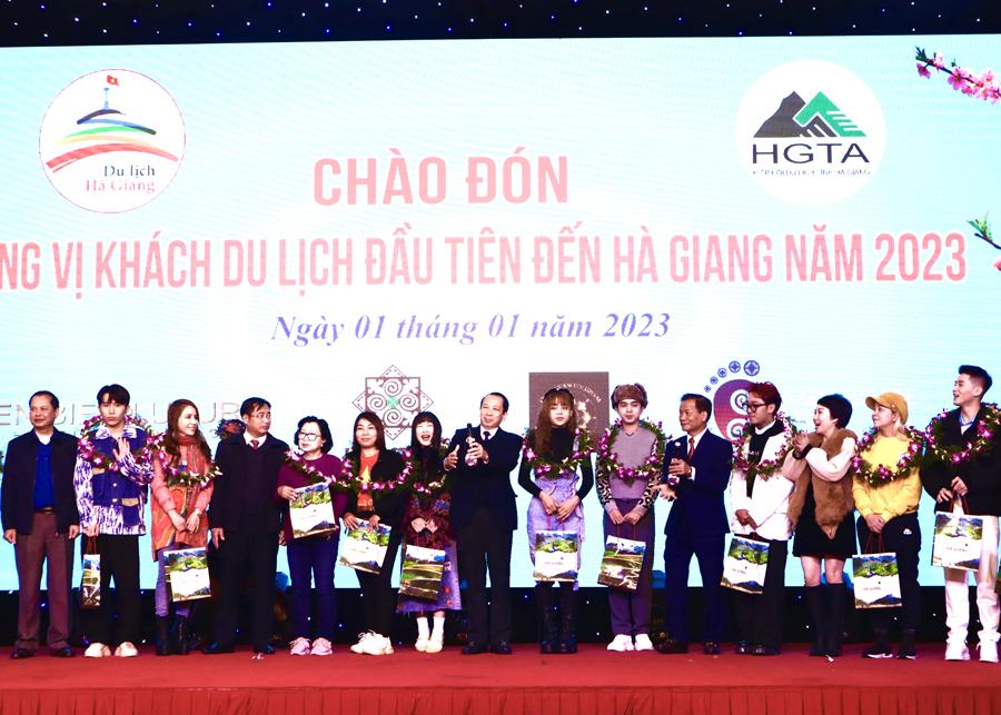 Đồng chí Trần Đức Quý tặng hoa và quà cho những vị khách đầu tiên đến Hà Giang năm 2023
