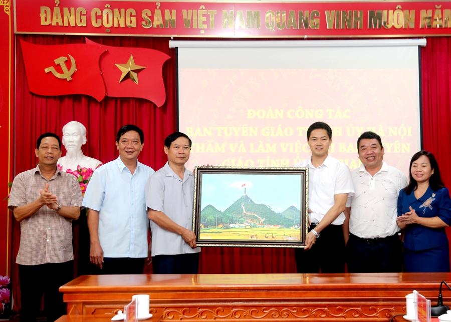 Lãnh đạo Ban Tuyên giáo Tỉnh ủy tặng đoàn công tác Ban Tuyên giáo Thành ủy Hà Nội bức tranh Cột cờ Quốc gia Lũng Cú.    Ảnh: VL