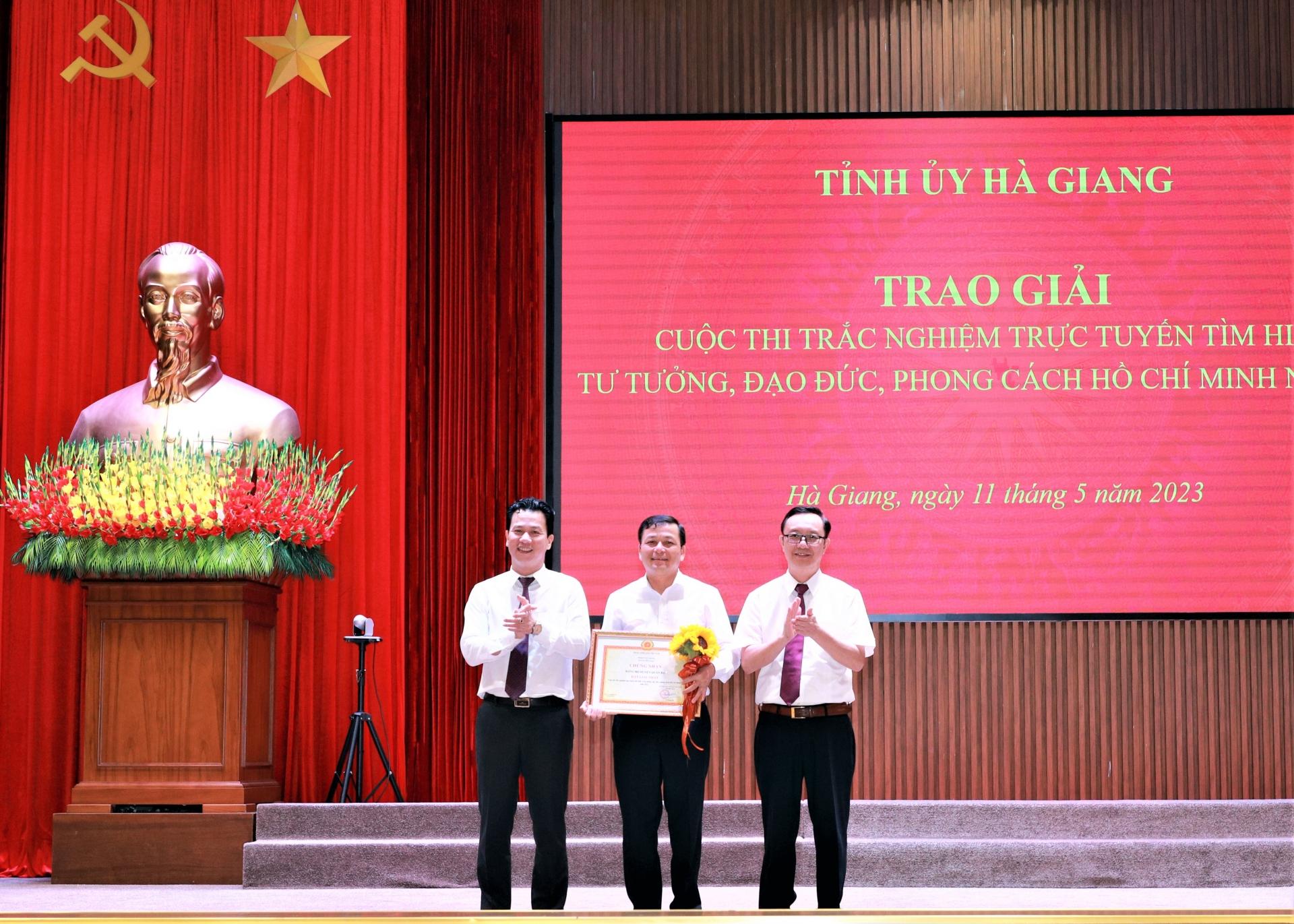 Bí thư Tỉnh ủy Đặng Quốc Khánh và Phó Bí thư Thường trực Tỉnh ủy, Chủ tịch HĐND tỉnh Thào Hồng Sơn trao giải Nhất tập thể cho Đảng bộ huyện Quản Bạ.