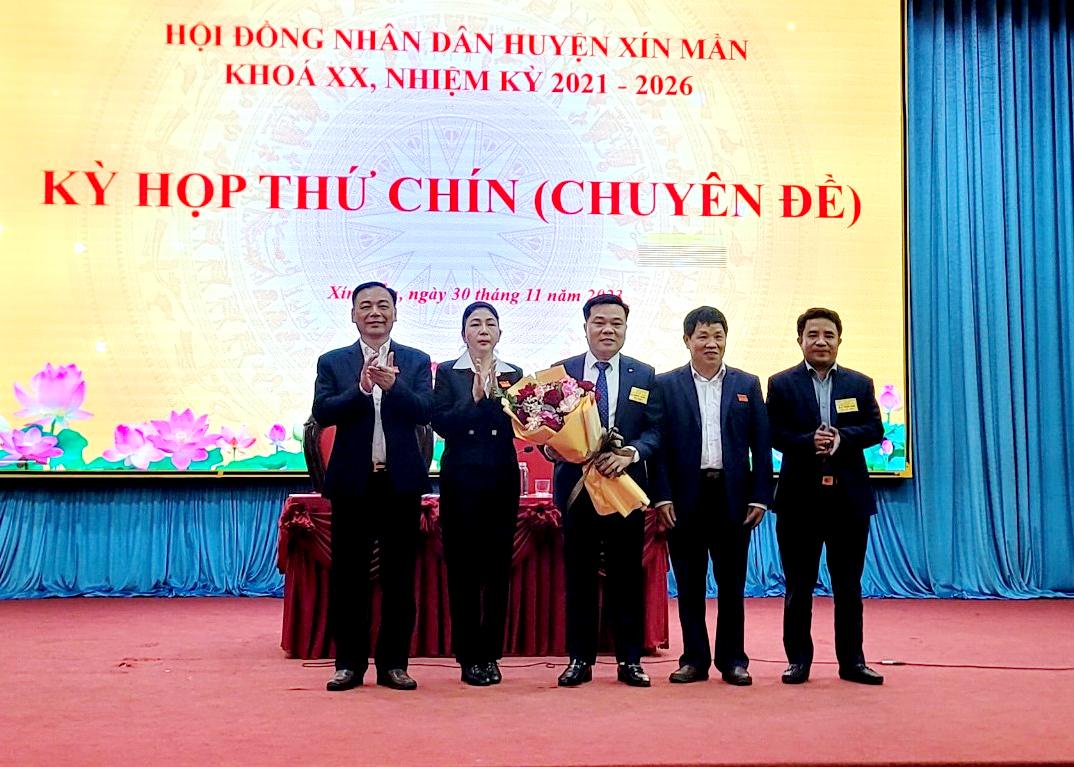 Thường trực HĐND - UBND huyện Xín Mần tặng hoa chúc mừng tân Chủ tịch UBND huyện Xín Mần Nguyễn Tiến Hùng.