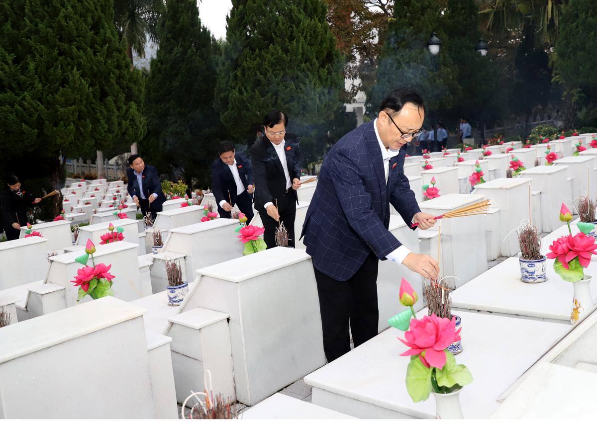 Chủ tịch HĐND tỉnh Thào Hồng Sơn và các đại biểu thắp hương lên các phần mộ.