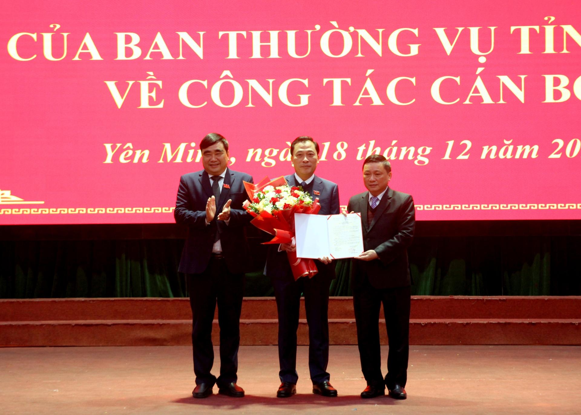 Đồng chí Nguyễn Minh Tiến và Hoàng Đình Phới trao quyết định, tặng hoa chúc mừng đồng chí Hoàng Anh Tuấn.
