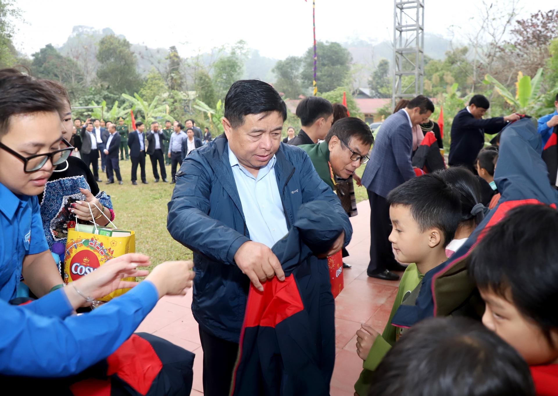 Bộ trưởng Bộ KH&ĐT Nguyễn Chí Dũng tặng quà các cháu học sinh tại làng Pinh.