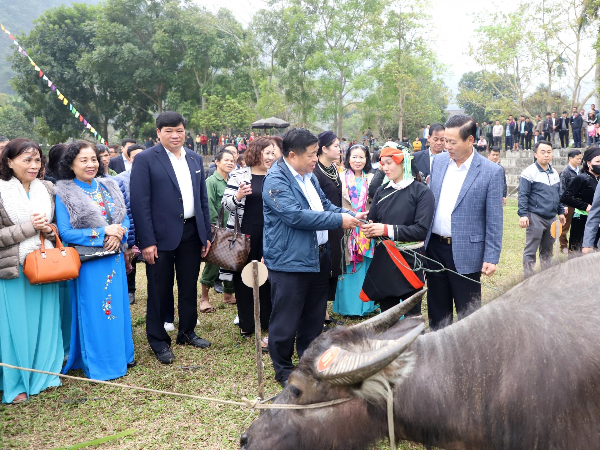 Bộ trưởng Bộ KH&ĐT Nguyễn Chí Dũng, Chủ tịch UBND tỉnh Nguyễn Văn Sơn tặng trâu cho các hộ đặc biệt khó khăn.