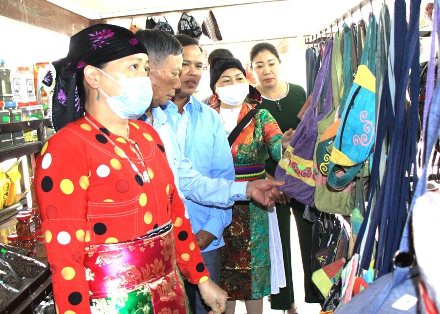 Cán bộ Trạm Thông tin du khách huyện Quản Bạ giới thiệu sản phẩm dệt lanh của địa phương cho khách du lịch
