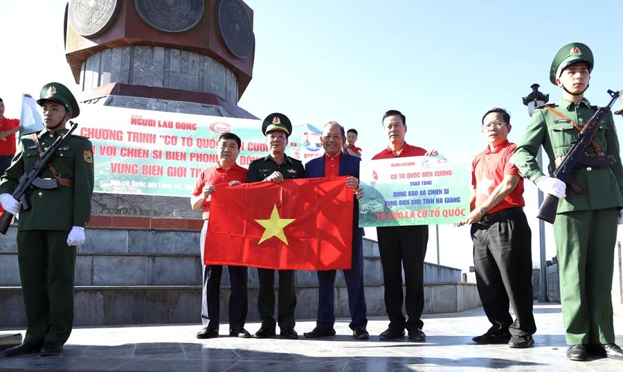 Nguyên Phó Thủ tướng Thường trực Chính phủ Trương Hòa Bình và Tổng Biên tập Báo Người Lao Động Tô Đình Tuân trao biểu trưng tặng 10.000 lá cờ cho tỉnh Hà Giang