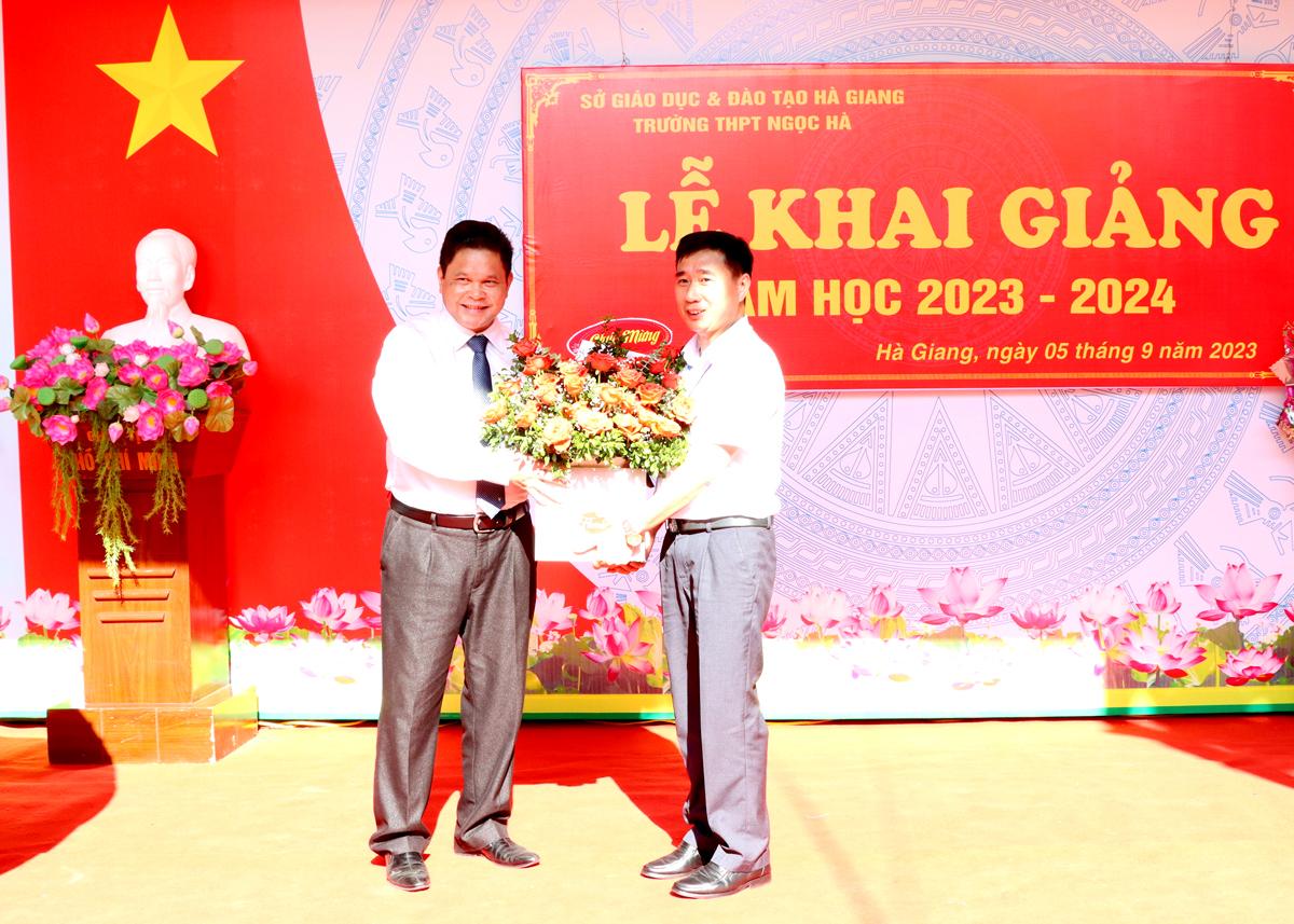 Chủ tịch Ủy ban MTTQ tỉnh Vàng Seo Cón tặng hoa cho tập thể cán bộ, giáo viên Trường THPT Ngọc Hà.