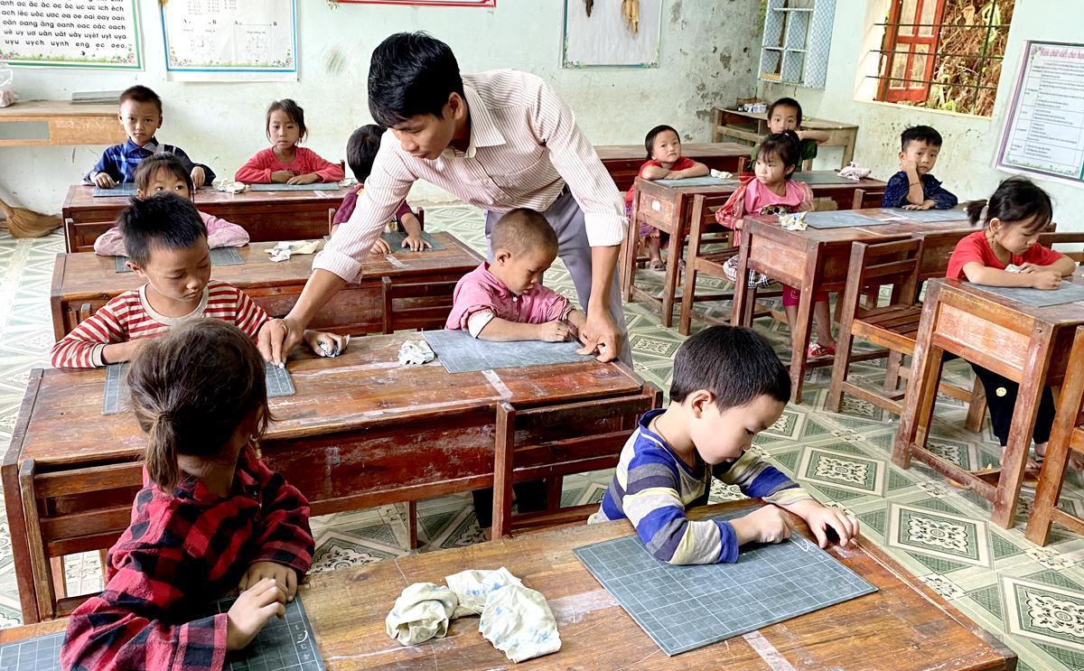 Thầy Nguyễn Thanh Tuấn, điểm trường Xín Chải, xã Bản Ngò (Xín Mần), luyện chữ cho học sinh.