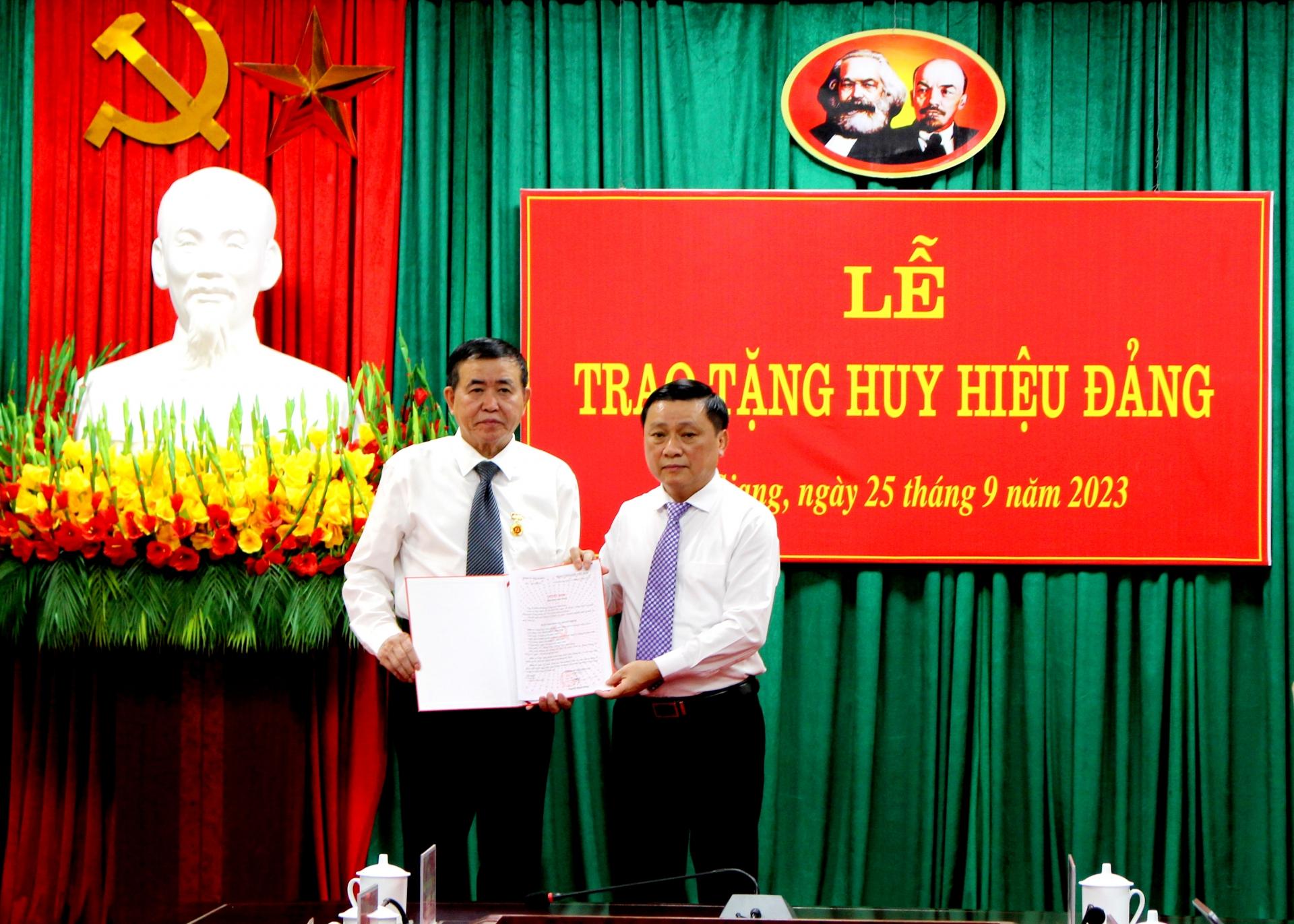 Trưởng Ban Tổ chức Tỉnh uỷ Nguyễn Minh Tiến trao Huy hiệu 30 năm tuổi Đảng cho đồng chí Nguyễn Văn Tuệ.