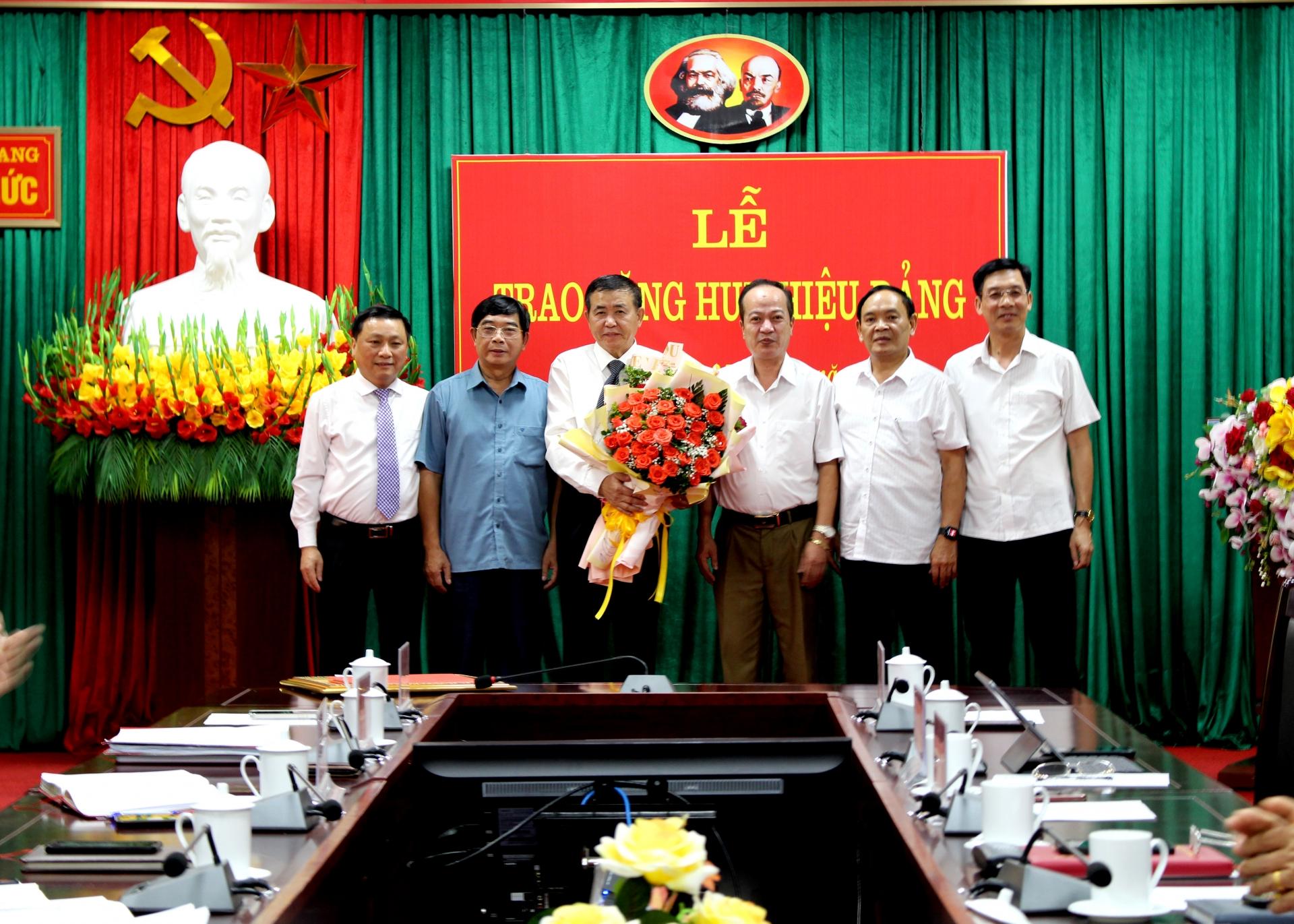 Các đại biểu tặng hoa chúc mừng đồng chí Nguyễn Văn Tuệ.