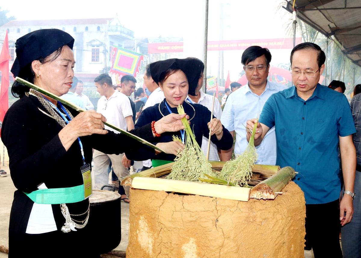 Lãnh đạo huyện Bắc Quang động viên cán bộ, đảng viên người Tày gìn giữ nghề làm cốm truyền thống.