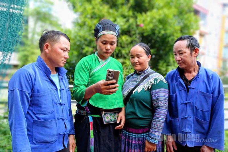 Người dân thôn Vũ Khí, xã Pà Vầy Sủ theo dõi cập nhật thông tin Đại hội qua điện thoại. Ảnh Văn Long